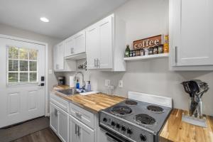 a kitchen with white cabinets and a stove at Downtown Kimmswick Studio Newly Renovated 