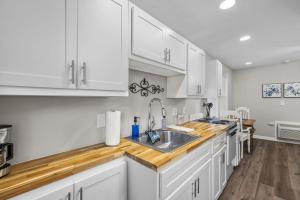 a kitchen with white cabinets and a sink at Downtown Kimmswick Studio Newly Renovated 