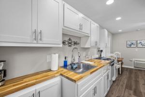 a kitchen with white cabinets and a sink at Downtown Kimmswick Studio Newly Renovated in Imperial