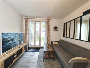 サン・ドニにあるAppartement avec jardin - Métro 13 - Université Saint Denisのソファと大きな窓のあるリビングルーム