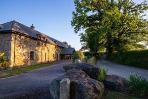 uma casa de pedra com pedras à frente em West Nymph Holiday Cottages Leafy Nook em South Tawton