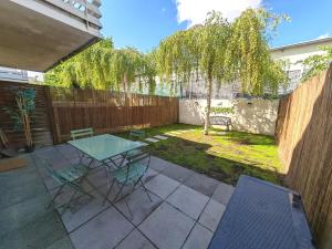 サン・ドニにあるAppartement avec jardin - Métro 13 - Université Saint Denisのパティオ(テーブル、椅子、フェンス付)