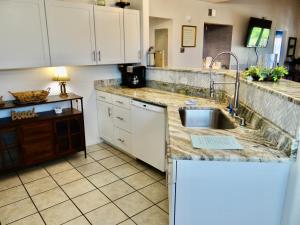 una cocina con armarios blancos y fregadero en 201D Jenns Bay Retreat, en Myrtle Beach