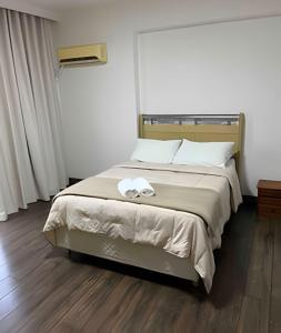 ein Schlafzimmer mit einem Bett und einem Handtuch darauf in der Unterkunft Apto no centro para família in Foz do Iguaçu