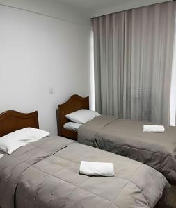 2 Betten in einem Hotelzimmer mit Handtüchern darauf in der Unterkunft Apto no centro para família in Foz do Iguaçu