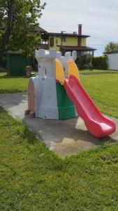 a playground with a red slide in the grass at Mansarda al mare in Pertegada