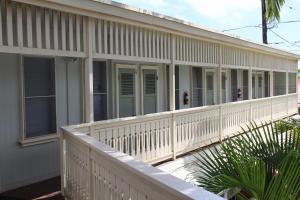 a building with a white fence and a porch at Kauai Palms Hotel in Lihue