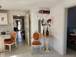 una cocina con una mesa con sillas y un jarrón con flores en Rustikale Wohnung, en Patzig