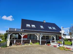 a house with a black roof and white columns at Rustikale Wohnung in Patzig