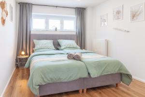 ein Schlafzimmer mit einem Bett mit zwei Handtüchern darauf in der Unterkunft nJoy! Relax & Sunny - Panorama Therme - Terrasse - perfekt für Business & Spa in Beuren