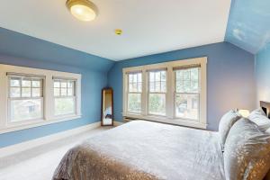 a bedroom with blue walls and a bed with windows at Harbor Haven in Seattle