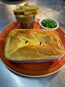 a pie on a plate with chips and peas at Dartmoor Halfway Inn in Newton Abbot