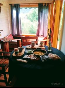 a table with food on it in front of a window at BALCON CORDILLERANO in El Bolsón