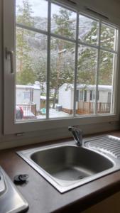 Mobilhome comfort à la montagne في Saint-Auban: مغسلة المطبخ أمام النافذة