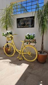 una bicicletta gialla parcheggiata accanto a un edificio con piante di Villa Giulia a Marinella di Selinunte
