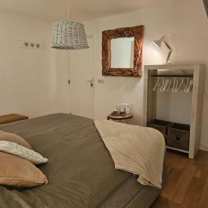 ein Schlafzimmer mit einem großen Bett und einem Spiegel in der Unterkunft Bed & Breakfast Serendipity in Valkenburg