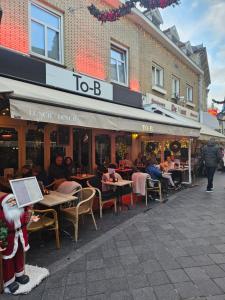 a group of people sitting at tables outside a restaurant at Bed & Breakfast Serendipity in Valkenburg