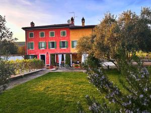 une maison rouge et orange avec une cour dans l'établissement Relais Valpolicella B&B, à Marano di Valpolicella