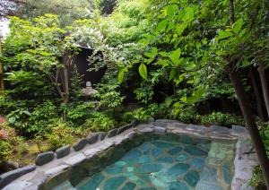 una piscina en medio de un jardín en Izuito Onsen Daitokan, en Ito