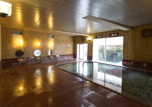 a swimming pool in a large room with a pool at Izuito Onsen Daitokan in Ito