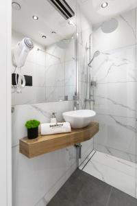een witte badkamer met een wastafel en een douche bij Rainbow Apartments Old Town in Krakau