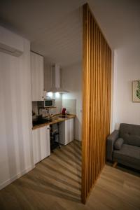 Una sala de estar con un sofá y una cocina. en Apartamentos GEMINA, en Mérida