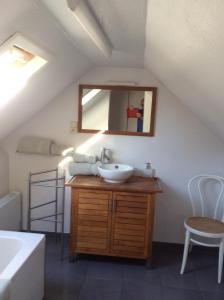 La salle de bains est pourvue d'un lavabo et d'un miroir. dans l'établissement Logies Villa Maxim, à Coxyde