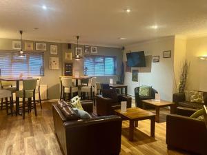 a living room with couches and tables and a bar at Haigs Hotel in Coventry