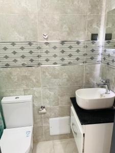 a bathroom with a white toilet and a sink at Dakar Creek in Dakar