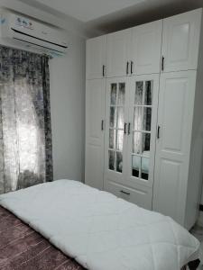 a bedroom with white cabinets and a white bed at Dakar Creek in Dakar