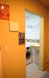 a bathroom with a washing machine and a sign on the wall at 40 LOFT DUPLO · LOFT perto do São Paulo Expo e metrô Jabaquara in Sao Paulo