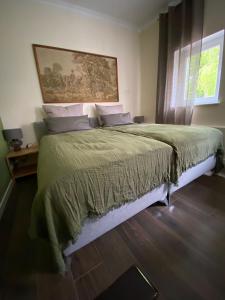 a bedroom with a large bed with a painting on the wall at Apartment im Hinterhof in Bersenbrück