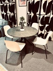a table with white chairs and a potted plant on it at Modern 2 bedroom Flat in Balham in London +70 photos