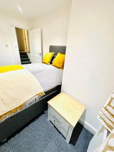 - une chambre avec 2 lits et des oreillers jaunes dans l'établissement Modern 2 bedroom Flat in Balham, à Londres