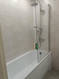 ein Badezimmer mit einer Dusche und einer weißen Badewanne in der Unterkunft BELLEVUE in Narva