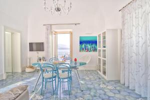 a dining room with a blue table and chairs at Devalù casa del mare in Cefalù