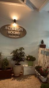 um quarto com vasos de plantas e uma placa na parede em Acheron rooms em Preveza