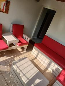 a room with two red chairs and a table at 5 On Cologne in Germiston