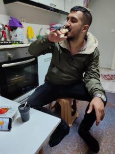 a man sitting in a chair eating food at 1643 suit apart in Çekirge