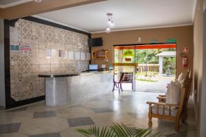 a kitchen with a counter and a bar in a room at Hotel Águas Lindas in Itamonte