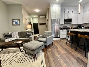 a living room with a couch and chairs and a kitchen at Downtown Whitefish awaits you at Central Ave Suite in Whitefish