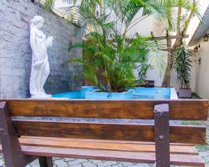 a statue sitting on top of a wooden bench at De Rose Palace Hotel in Torres