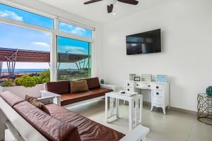 een woonkamer met een bank en een tv bij Villa Turquesa 56 - Playa Arcangel in Rosarito