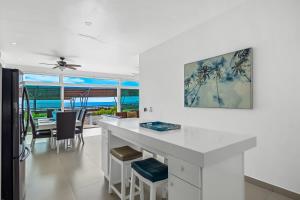 een witte keuken met een eettafel en uitzicht op de oceaan bij Villa Turquesa 56 - Playa Arcangel in Rosarito