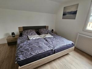 um quarto com uma cama com edredão e almofadas roxas em Time-Out em Monschau