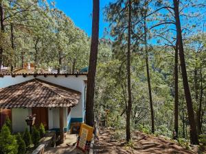 a house in the woods with a sign in front of it at BACANA CABAÑAS DE ALQUILER in Mazamitla