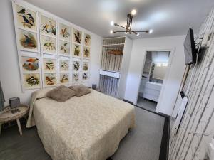 1 dormitorio con 1 cama y una pared de cuadros en Estudios Playa de Covachos, en Soto de la Marina