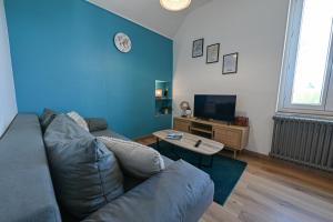 a living room with a couch and a tv at La Belle Rive du voyageur in Bellerive-sur-Allier