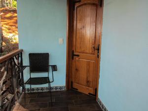 a chair sitting on a porch next to a door at BACANA CABAÑAS DE ALQUILER in Mazamitla