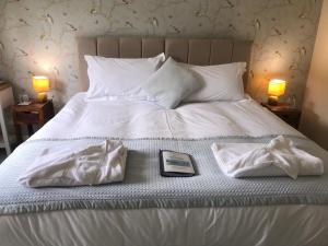 a bed with two towels and a book on it at Bransford Farm Fishery & B & B in Bransford